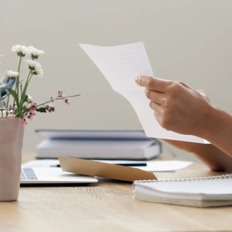 Woman-at-desk-holding-paper