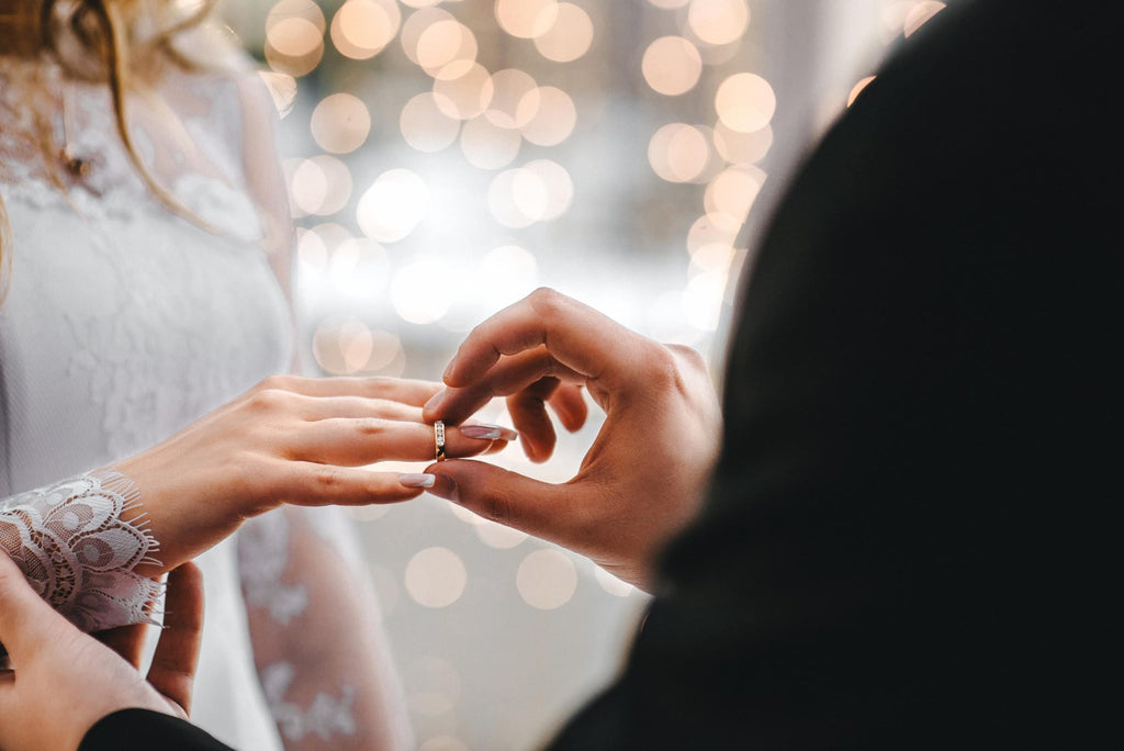groom puts ring on brides finger